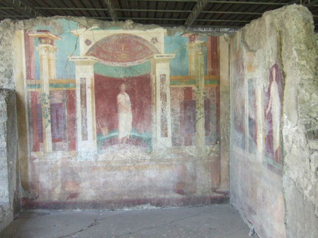 VI.17.41 Pompeii. May 2006. Exedra on north side of cubiculum. Looking east towards architectural paintings of robed figures.
The flooring was of a carpet mosaic of black tesserae with regular dots of white tesserae, flakes and tiles of alabaster and polychrome marble arranged in a very sparse basket weave: the border was of white tesserae.




