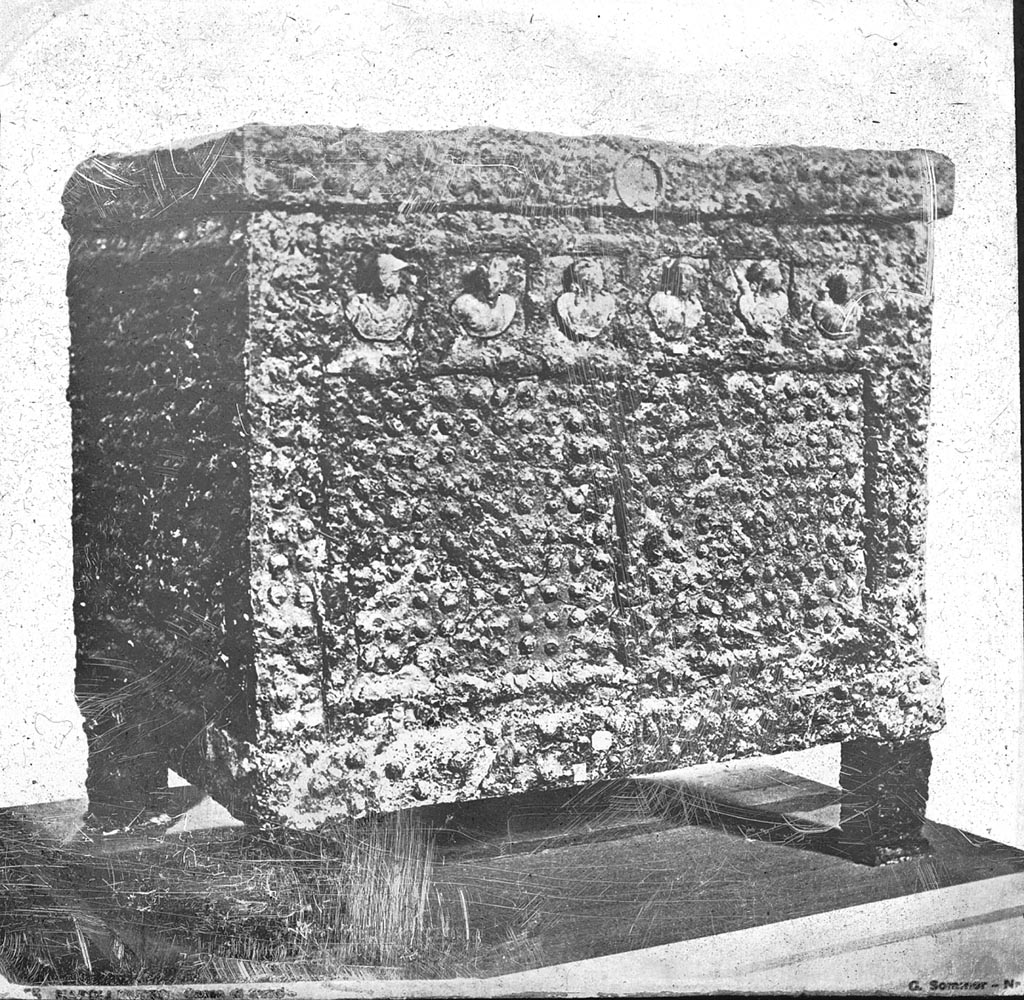 According to Milanese, in the National Archaeological Museum of Naples four arcae ferratae (money chests) are preserved: 
Three safes are documented in the above photo [left to right], from around 1885, from the Sala dei Piccoli Bronzes made by the photographer Achille Mauri.
The safe with sacrifice to Jupiter [from VII.7.5], inv. 73020.
The safe [from VII.2.18] with Eros and Psyche, inv. 73021. 
The safe with busts of deities [from Pompeii], inv. 73022.
The fourth safe from the House of the Vettii restored by the Central Institute for the Restoration was not discovered until after this photograph was taken. 
See Milanese, A., 2009. Album museo. Immagini fotografiche ottocentesche del Museo Nazionale di Napoli, Napoli, pp. 156-161.
