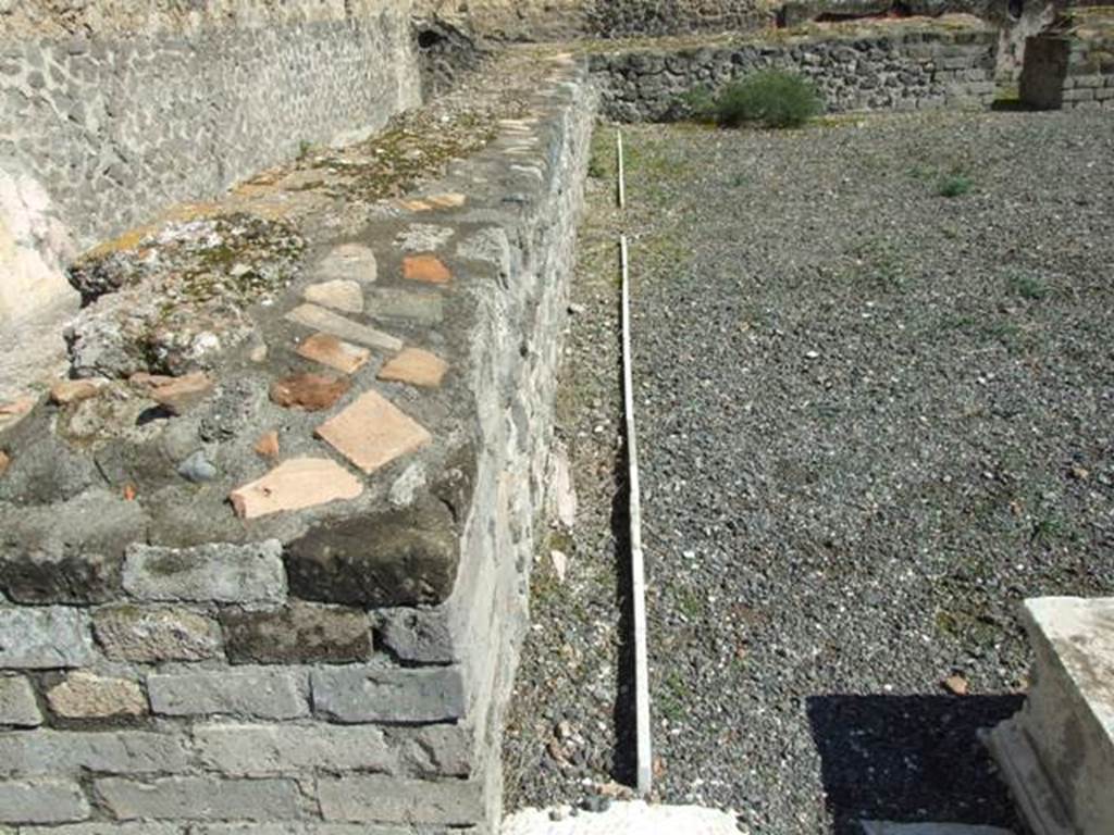 VII.9.7 and VII.9.8 Pompeii. Macellum. March 2009. Large room in south-east corner.  
Looking east along the front of counter at north end.  A water channel ran round the counter conveying running water.
