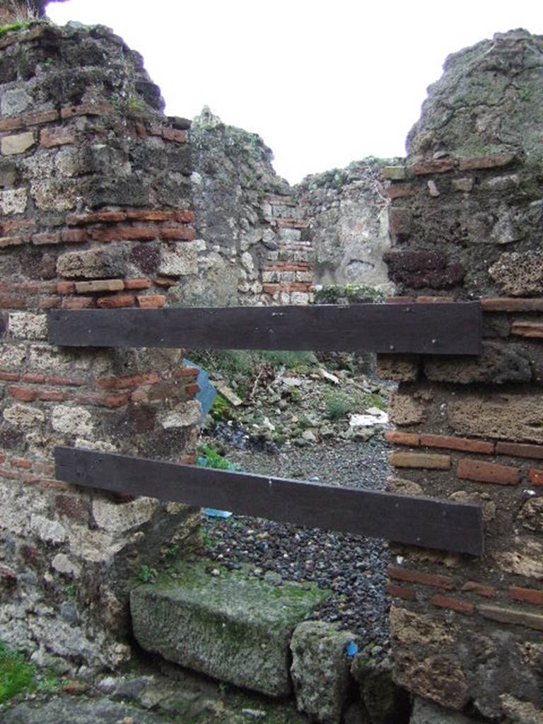 VII.13.12 Pompeii. December 2005. Looking west through doorway into kitchen, with remains of hearth (on left).