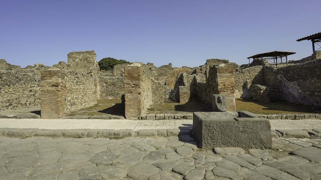 VII.14.13 Pompeii. August 2021. 
Looking north on Via dell’Abbondanza towards shop at rear of fountain, on left. Photo courtesy of Robert Hanson.
