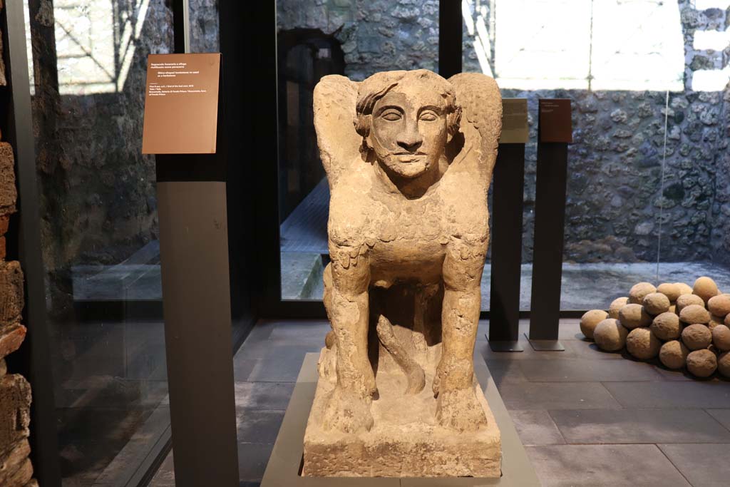 VIII.1.4 Pompeii. February 2021. 
Tufa sphynx-shaped tombstone, re-used as a kerbstone, found at the farm of Fondo Prisco, Boscoreale.
Photo courtesy of Fabien Bièvre-Perrin (CC BY-NC-SA).
