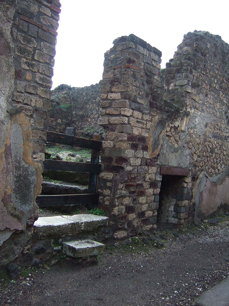 VIII.2.27 Pompeii. December 2005. 
Looking through doorway with steps to kitchen area of VIII.2.26, and window of underground room, on right.



