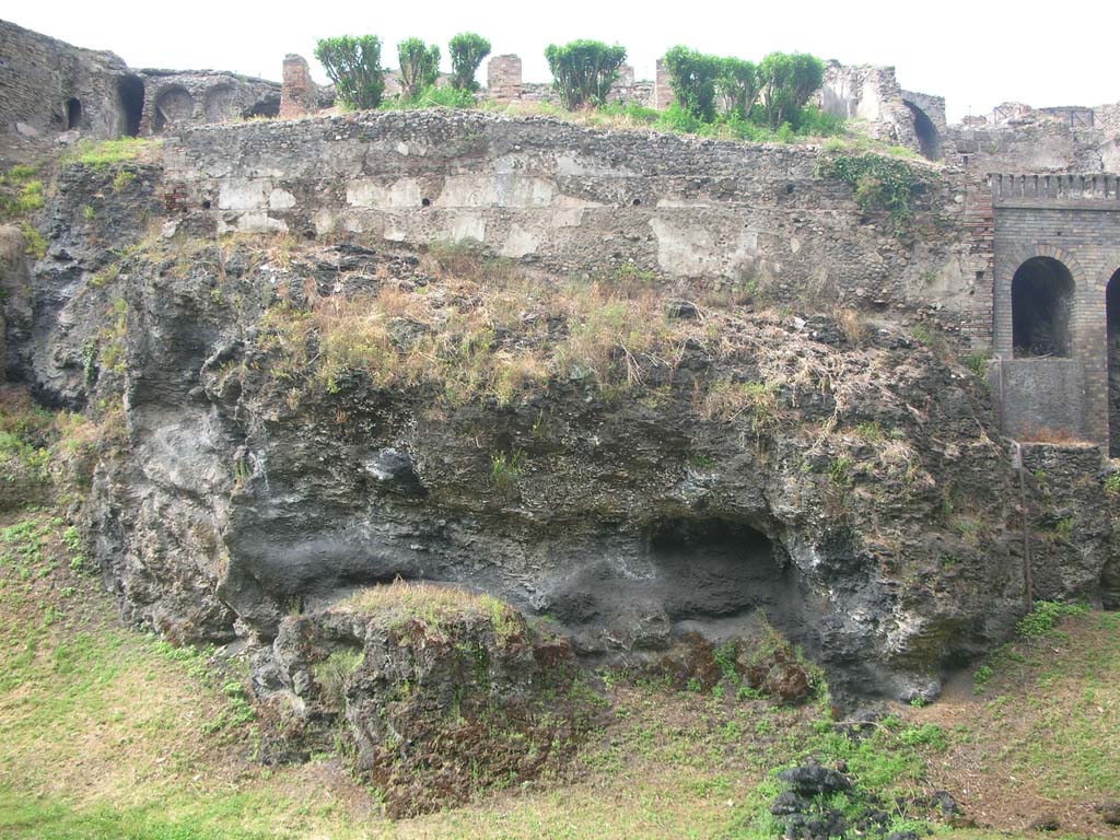 VIII.2.30 Pompeii, May 2011. Looking north to city walls above volcanic ledge. Photo courtesy of Ivo van der Graaff.
According to Van der Graaff –
“Terrace 19 in House VIII.2.30 displays a similar superimposition of construction techniques (to VIII.2.29), with travertine blocks partially covered in later plaster and incorporated into opus incertum masonry. (Note 22, see Noack and Lehmann-Hartleben 1936, p.5-15).” 
See Van der Graaff, I. (2018). The Fortifications of Pompeii and Ancient Italy. Routledge, (p.49).
