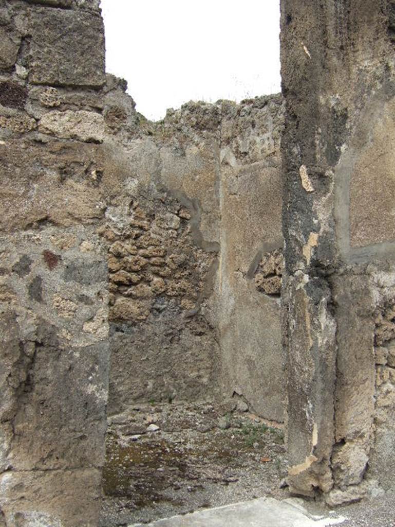 VIII.2.34 Pompeii. May 2006. Looking north-west through doorway of cubiculum ‘k’ on west side of atrium ‘c’. The flooring found in this room was of cocciopesto with a net of meandering swastikas, alternating with squares with a white central cross. When excavated, only a fragment of black zoccolo was found on the east wall.
