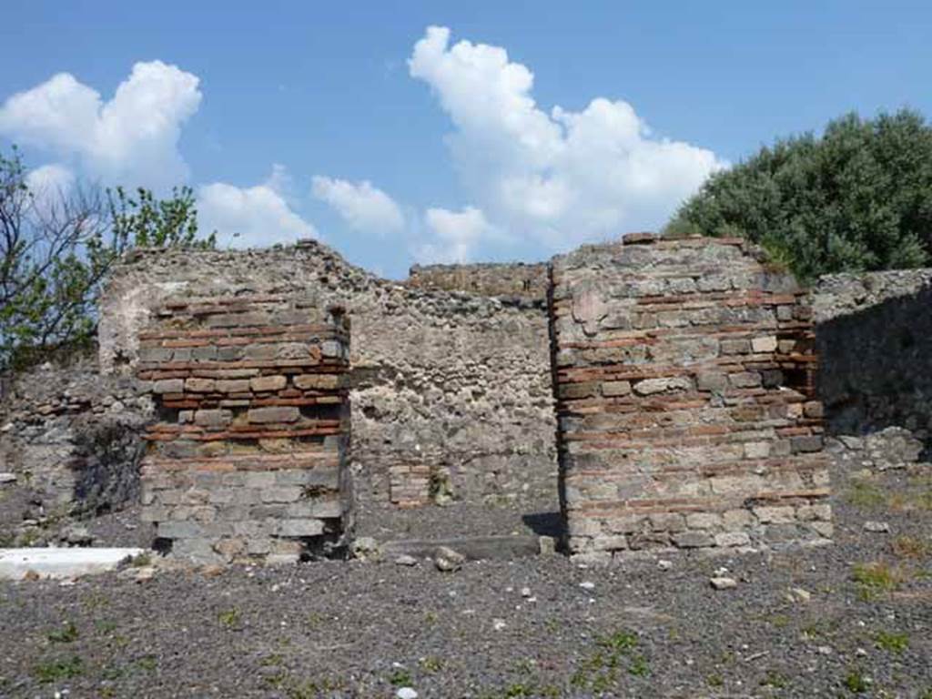 VIII.3.15 Pompeii. May 2010. Looking north towards doorways to south portico 8 of garden area, from entrance. 
The two square pillars supported the portico on the south side of the garden and were painted with vines, according to Jashemski.
See Jashemski, W. F., 1993. The Gardens of Pompeii, Volume II: Appendices. New York: Caratzas, (p. 211).
The left pilaster would have separated the walls of rooms 2 and 1, the right pilaster would have separated rooms 1 and 9.

