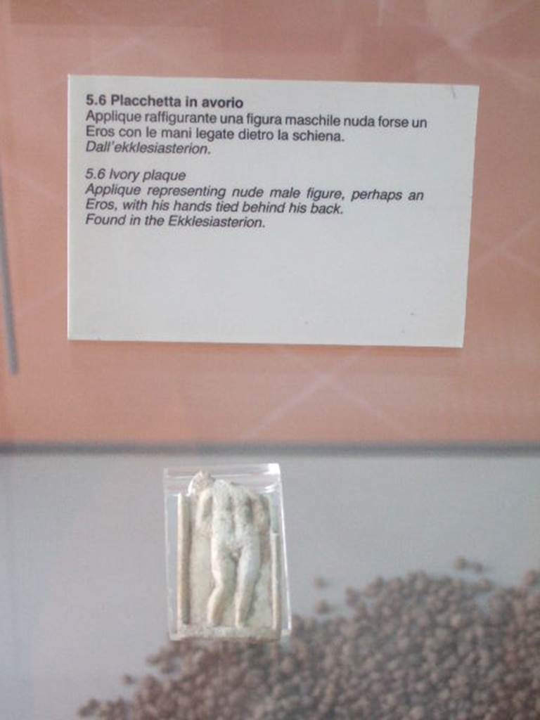 VIII.7.28 Pompeii. Found in the sacrarium or Ekklesiasterion. 
The Museum label says the Ekklesiasterion but the Museum website says the sacrarium.
Ivory plaque of male figure with hands tied behind his back. 
The presence of a wing, suggested by a ripple on the top-left margin, leads us to believe that this is a Cupid, represented according to the iconography of Eros punished, with the hands tied.
Now in Naples Archaeological Museum. Inventory number s. n. 7.

