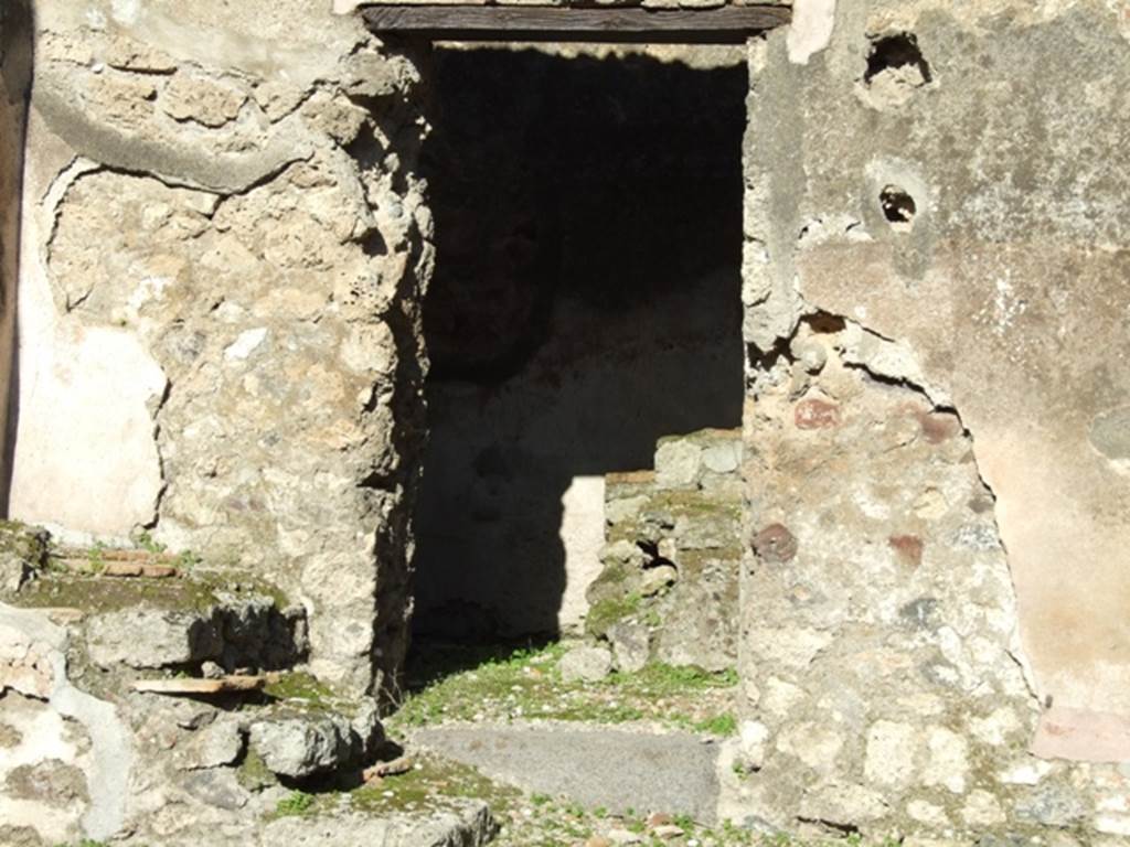 IX.1.4 Pompeii. March 2009. Doorway to rear kitchen room in east wall of shop. In December 1852, an inscription was found in this room:
Carmina(m)
communem ne
arma virumque cano tro   [CIL IV 2361]
Now in Naples Archaeological Museum.  Inventory number 111970.
See Pagano, M. and Prisciandaro, R., 2006. Studio sulle provenienze degli oggetti rinvenuti negli scavi borbonici del regno di Napoli.  Naples : Nicola Longobardi.  (p.167)
According to Fiorelli it read:
CARMINA
      COMMVNEMNE
ARMA . VIRVMQVE CANO TRO
See Pappalardo, U., 2001. La Descrizione di Pompei per Giuseppe Fiorelli (1875). Napoli: Massa Editore. (p.137)
