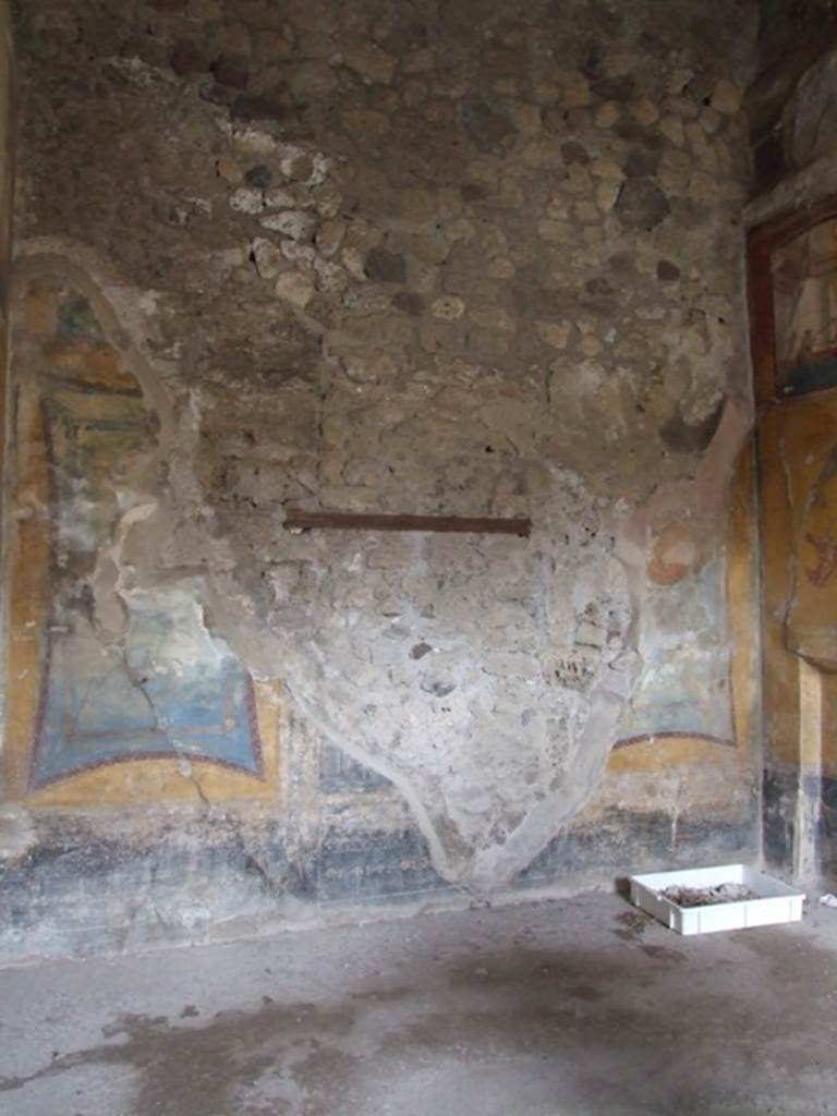 IX.1.7 Pompeii. December 2007. West wall of triclinium. According to PPP, the decorative scheme on this wall differed from the other walls because of the side panels. They were on a yellow background but with blue insert with a red border and medallions. On the north end (right) on the blue background would have been the medallion (diam. 0.28) showing Hercules and Omphale. On the south end (left) would have been the medallion showing a Maenad and Silenus with thyrsus and cup. The zoccolo/plinth was black and would have showed traces of birds with long legs.
See Bragantini, de Vos, Badoni, 1986. Pitture e Pavimenti di Pompei, Parte 3. Rome: ICCD. (p.386).

