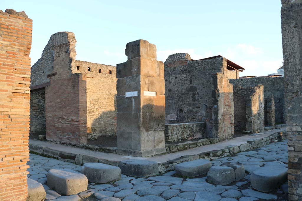 IX.1.15 Pompeii, centre left, and IX.1.16, centre right on Via dell’Abbondanza. December 2018. 
Looking north-east from Holconius’ crossroads, towards bar with two entrances. Photo courtesy of Aude Durand.
