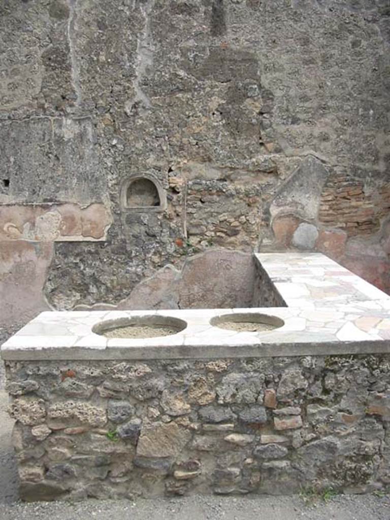 IX.1.16 Pompeii. May 2003. Looking east across counter towards wall with niche. Photo courtesy of Nicolas Monteix.