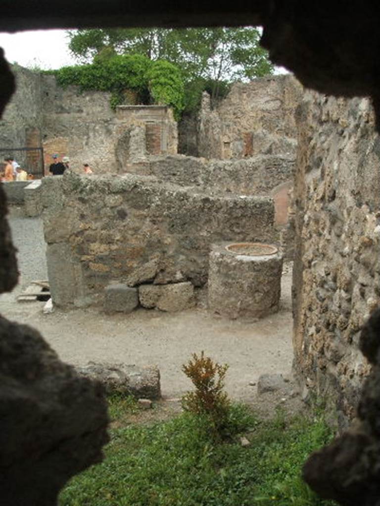 IX.1.33 Pompeii. May 2005.  Looking west from hole in brickwork of IX.1.32, along the south side of the oven in IX.1.33. IX.1.3 is seen in the background.


