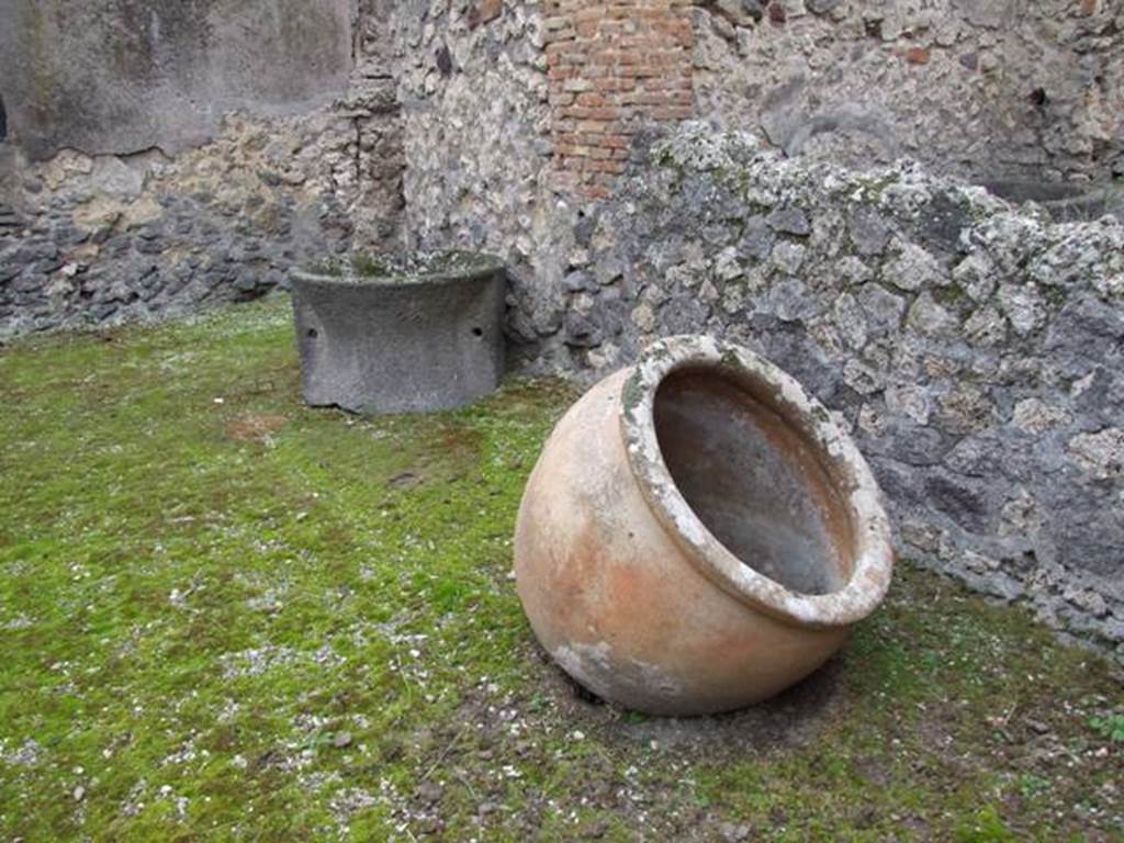 IX.3.20.  Bakery.  December 2007.  Room 1.  Remains of terracotta pot and Tufa mill.