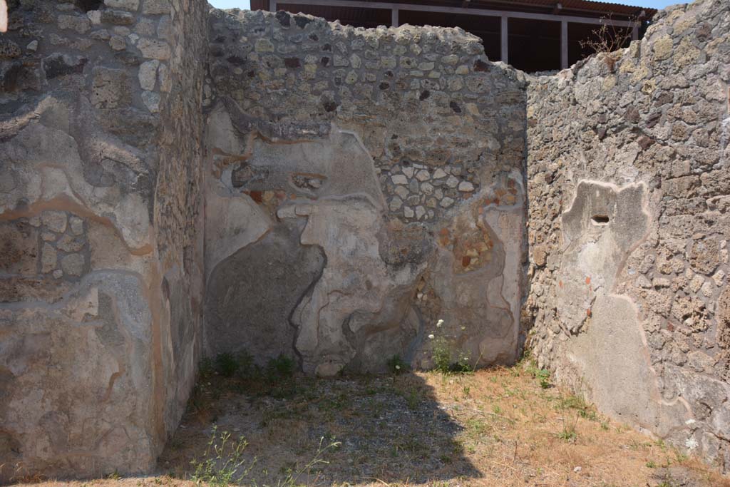 IX.7.19 Pompeii. July 2017. Looking north in ala c
Foto Annette Haug, ERC Grant 681269 DÉCOR.

According to Mau, when excavated the following paintings were found on the walls of this room.
Room c, the ala:
In the middle of the back (north) wall, - fish and shells in water (size: height 0.23m x length 0.31m - the right side was missing (half destroyed, according to Not.di Scavi, 1880, p.491).
On the sides of the back (north) wall – medallions enclosed in garlands (size: 0.20) –
on the left was the head of Diana crowned with leaves, with two javelins. She had dark hair with a narrow necklace around her neck and was wearing a red tunic buckled above both shoulders with a gold coloured buckle.
on the right was the head of Helios, with halo and blue rays, with a whip on the right shoulder. He had long blonde hair and was dressed the same as Diana.
On the right (east) wall, the remains of a destroyed lararium painting was found.
See Mau, in Bullettino dell’Instituto di Corrispondenza Archeologica (DAIR), 1883, (p.79).
See Sogliano, in Notizie degli Scavi di Antichità, 1880, (p.491).
According to Boyce, on the east wall of the left ala, a fragment of a lararium painting was seen at the time of excavation.
The fragment represented a single serpent moving amongst foliage.
See Boyce G. K., 1937. Corpus of the Lararia of Pompeii. Rome: MAAR 14. (p.88, no.437)  
See Fröhlich, T., 1991. Lararien und Fassadenbilder in den Vesuvstädten. Mainz: von Zabern. (p.112)
