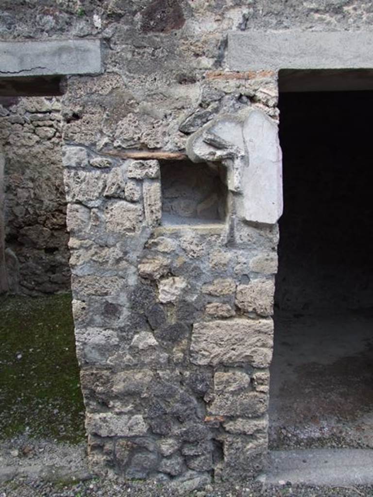 IX.9.c Pompeii. March 2009. North wall of north-west corner of portico.  
According to Boyce, in the pillar that separates two doorways on the north side of the peristyle was a rectangular niche. The niche was adorned with a stucco aedicula façade which consisted of two half-columns supporting a pediment. In the tympanum was a patera upon a bluish background. Also according to Boyce, a bronze figure of Hygeia seated upon a throne with her feet upon a footstool, was found in a room to the left of the fauces. On each side of the throne stood a small tree, around which coiled a serpent. See Boyce G. K., 1937. Corpus of the Lararia of Pompeii. Rome: MAAR 14. (p.93, no.467, and Note 4) 
  