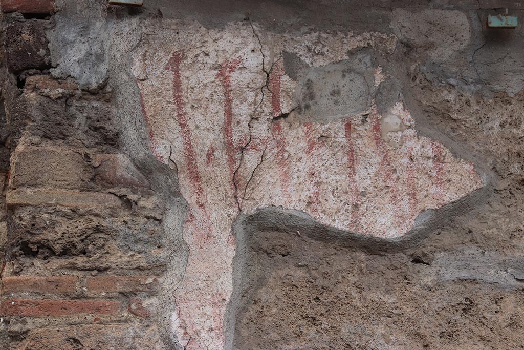 IX.11.8 Pompeii. October 2024.
Detail of remaining graffiti (CIL IV 7889) on front wall, east of doorway, at east end of insula. Photo courtesy of Klaus Heese. 
