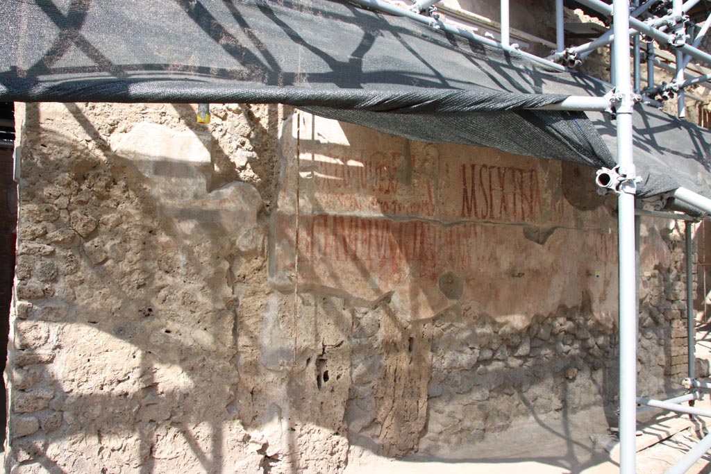 IX.12.6/7 Pompeii. October 2023. Graffiti on east side of doorway at IX.12.6, between IX.12.6 and IX.12.7. Photo courtesy of Klaus Heese.