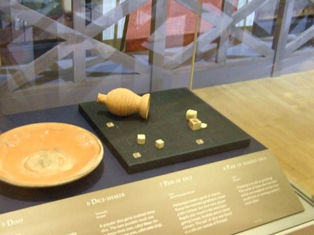 Villa of Mysteries, Pompeii. Location not specified. Pair of bone dice (on left of black base). SAP inventory number 4460a. Photographed at “A Day in Pompeii” exhibition at Melbourne Museum. September 2009.