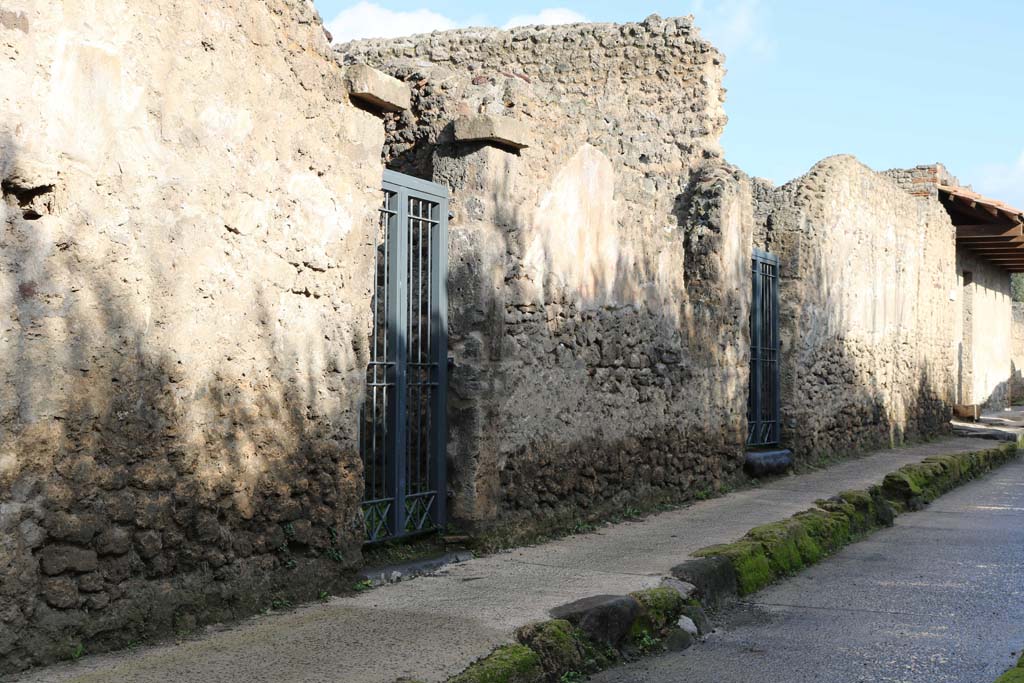 Via di Castricio, Pompeii. December 2018. Doorways to I.8.14 and I.8.13 on north side of roadway. Photo courtesy of Aude Durand.