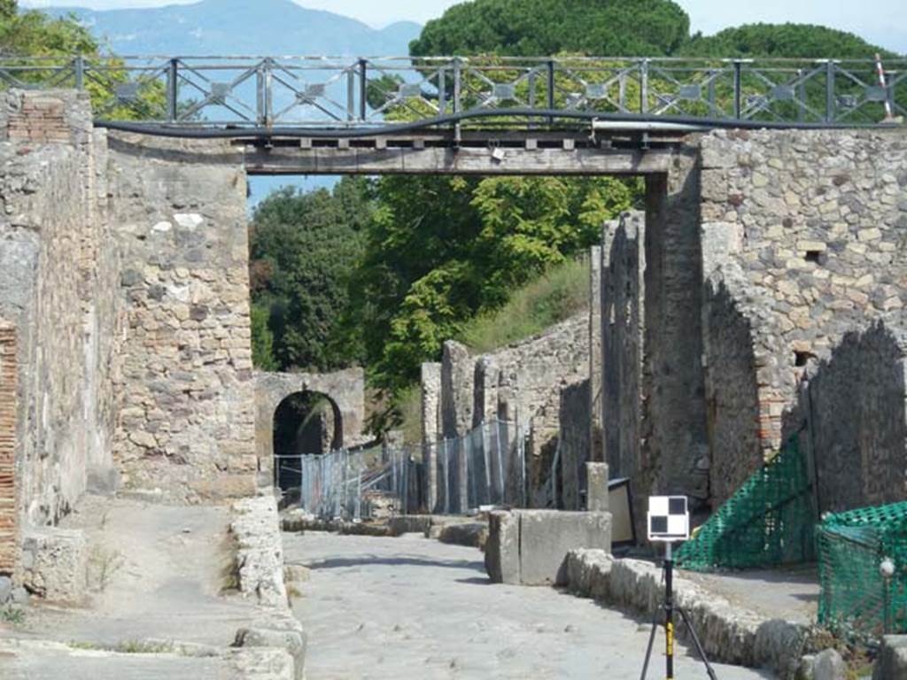 Via di Nola, south side. September 2015. Looking east from V.5.4 through the modern bridge towards IX.14 and the Nola Gate. 
