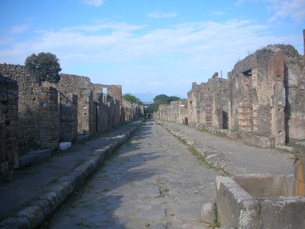 Via di Nola, Pompeii. May 2010. 
Looking east between V.3 and IX.8 along roadway towards Nola Gate. Photo courtesy of Ivo van der Graaff.
