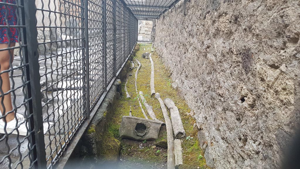 Vicolo di Mercurio. August 2023. 
Looking east along line of ancient water pipes on the edge of the road at the north end of VI.13. Photo courtesy of Maribel Velasco
