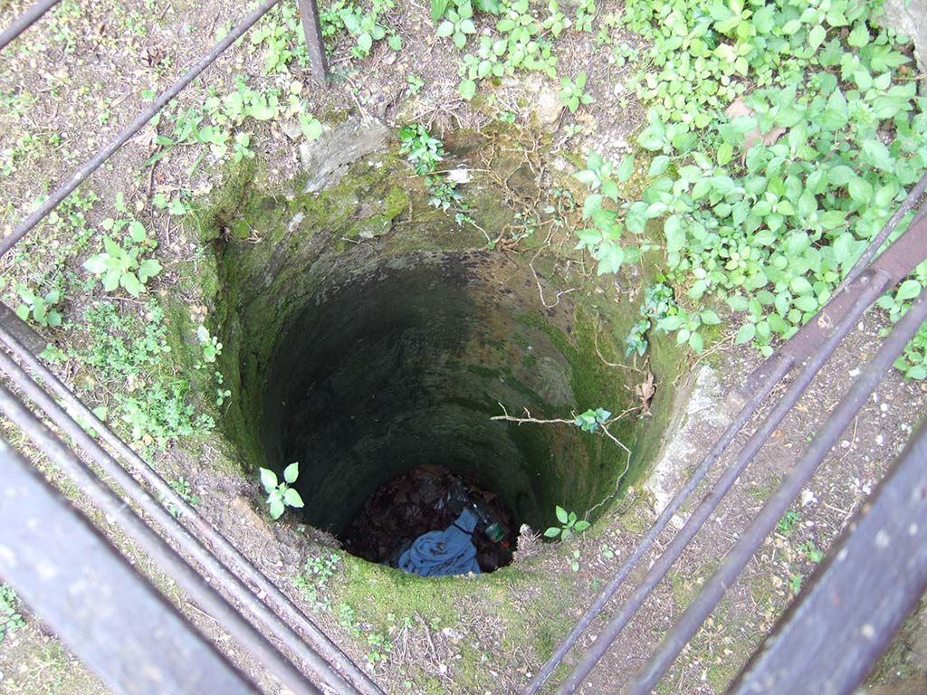 HGE13 Pompeii. May 2006. Cistern or well near south wall on right of entrance doorway.