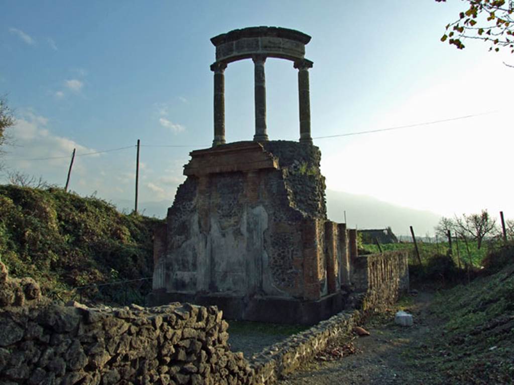 HGW04a Pompeii. December 2006. Looking west from Via dei Sepolcri.
The tomb has a circular aedicula reconstructed on top of the high podium.
