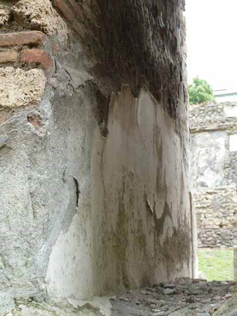 Pompeii Porta Nocera. May 2010. Detail of remains of plaster on west wall of 12EN. 
Looking south. 
