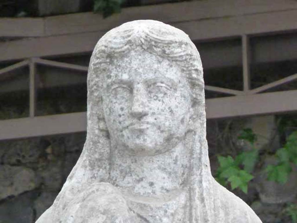 Pompeii Porta Nocera Tomb 34aEN. May 2010.
Detail from statue of a female in tunic and cloak covering part of the head. 
