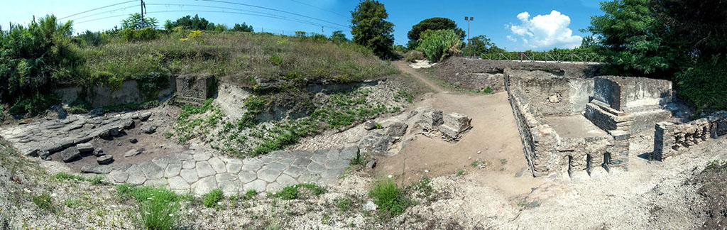 Pompeii Porta Sarno Necropolis. Panoramic view looking north. Tomb enclosures A and B are on the right with area D in front and area H to its left with area J the space between the funeral precincts and the area of the Samnite necropolis behind it. 
On the left of the picture are paved area E, area K and paved area E with square area G a funerary monument south of the auxiliary road still partially buried.
The continuation of the Via dell'Abbondanza, area E, the ancient road from the gate, now blocked by the railway, is to the left running west to east.
Photo courtesy Necropolis of Porta Sarno Research Project.
