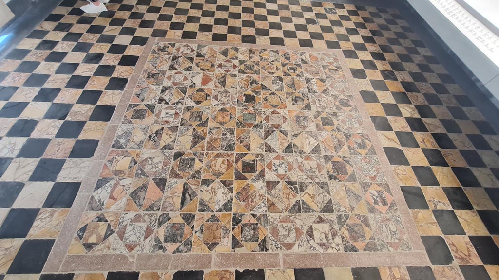 Opus Sectile floor on display in room CXLII on First floor in Naples Museum. June 2024. Photo courtesy of Giuseppe Ciaramella.
According to Ruggiero –
104 - “Il pavimento e scandita da un reticolo, formato da una fascia di marmo cipollino, nei cui scomparti sono racchiuse serie di quattro quadrelli. Questi sono formati da un quadrato sulla punta attorno al quale sono quattro triangoli che alternano i colori.”
(The floor is punctuated by a grid, formed by a band of cipollino marble, in whose compartments a series of four squares was enclosed. These are formed by a square, at the tip around which are four triangles of alternating colours.)
See Ruggiero, M. Degli scavi di Stabia dal 1749 al 1782, (p.119).
See Pisapia, M. S. 1989, in Mosaici antichi in Italia, Regione prima. Stabia, Roma, Room 104: p.54-55. (Room 104 is the same as our Room 13).
