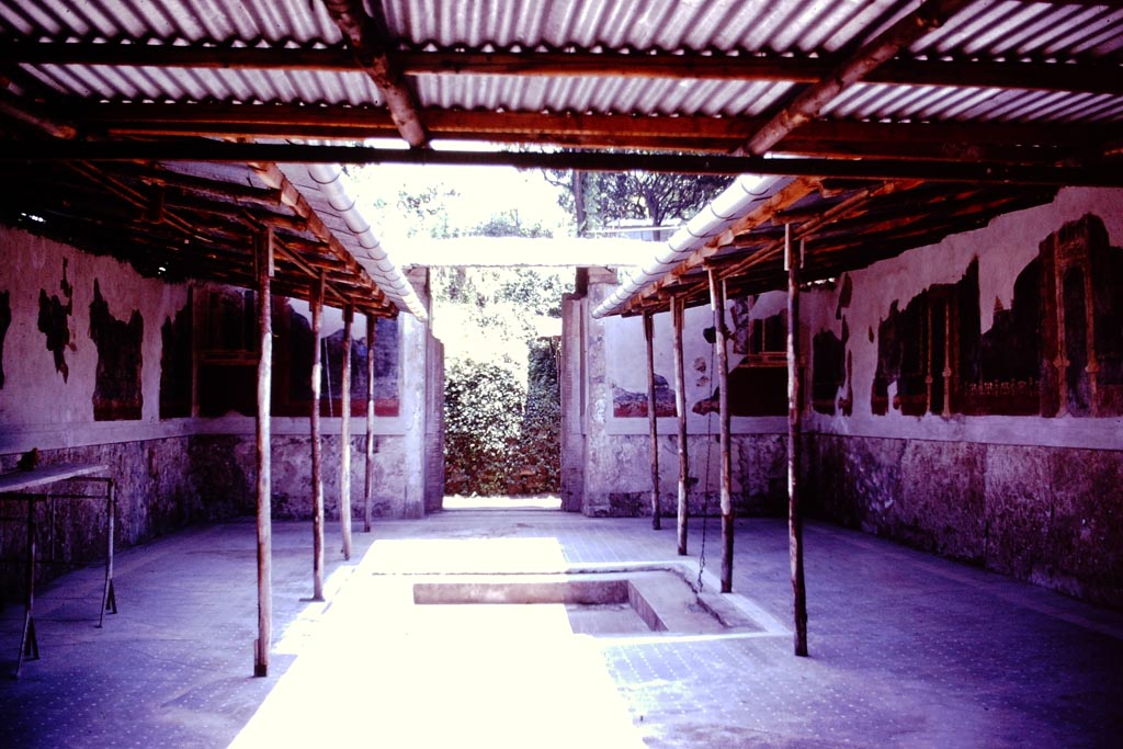 Stabiae, Villa Arianna, 1976. 
Looking south across impluvium in atrium, towards doorway leading to porticoed courtyard. Photo by Stanley A. Jashemski. 
Source: The Wilhelmina and Stanley A. Jashemski archive in the University of Maryland Library, Special Collections (See collection page) and made available under the Creative Commons Attribution-Non Commercial License v.4. See Licence and use details.
J76f0526
According to Wilhelmina, 
“This magnificent villa, located on the ridge of Varano to the west of the Villa of the Pastore, was explored by tunnelling from 1757 to 1761, and a plan was drawn by Weber. The villa was then partially excavated in 1950. Only three columns of the peristyle, which was in front of the atrium, have been excavated, but the entire peristyle, and surrounding rooms, are shown on Weber’s plan dated 1760.”
See Jashemski, W. F., 1993. The Gardens of Pompeii, Volume II: Appendices. New York: Caratzas, (p.308)  
