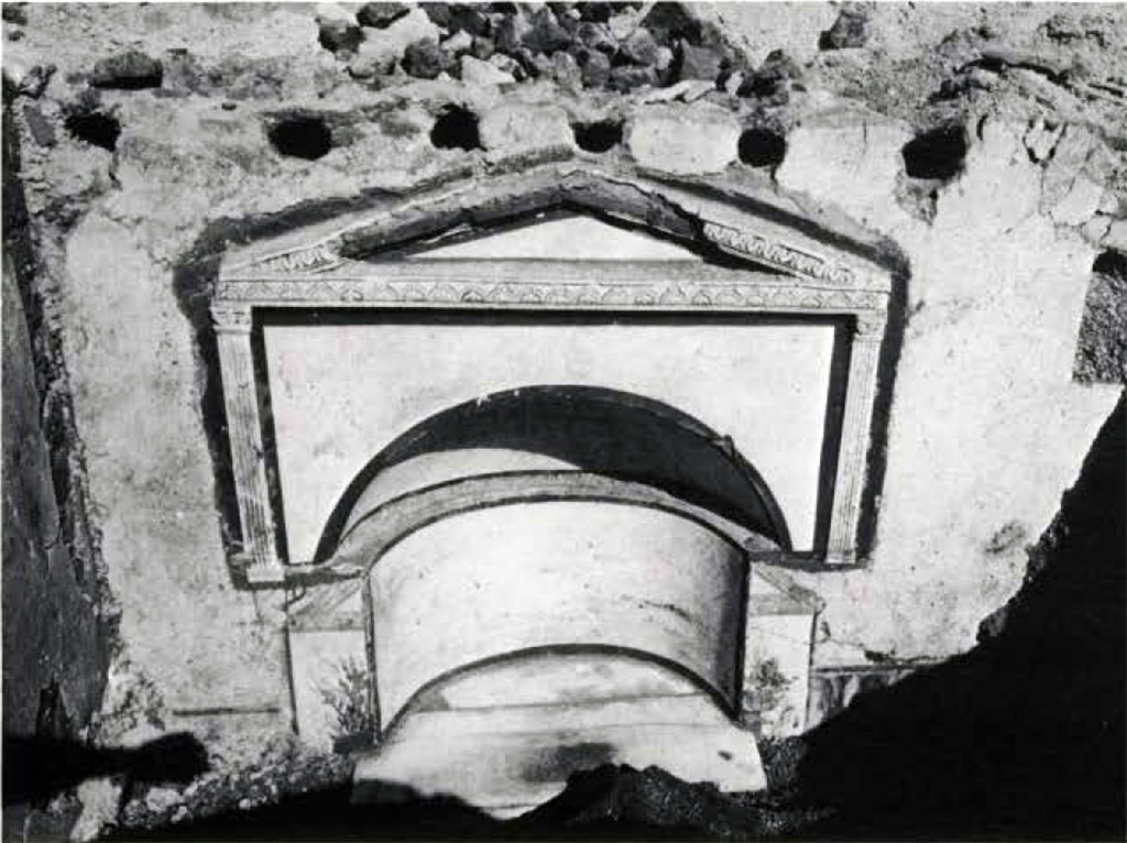 Boscoreale, Villa rustica in via Casone Grotta, proprietà Risi di Prisco. Lararium.
The pediment is supported by half-pilasters in stucco with framed leaf capitals decorated with plant motifs. 
The two angles of another pediment in plaster, visible below, belong to a previous niche of more reduced dimensions.
See Fergola, L., 1987. Comune di Boscoreale. Via Casone Grotta, proprietà Risi Di Prisco, in Rivista di Studi Pompeiani, I, p. 164, fig. 25.