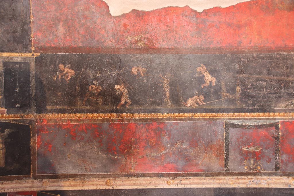 VI.15.1 Pompeii. October 2024. 
Predella in centre of north wall, painted panel of cupids gathering and pressing grapes. Photo courtesy of Klaus Heese.
