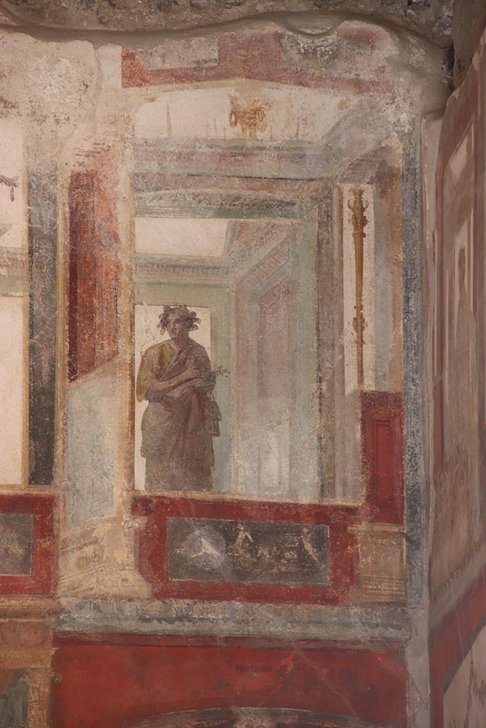 VI.15.1 Pompeii. October 2024.
Upper east wall of exedra, painted figure with panel below, from south end of east wall. 
Photo courtesy of Klaus Heese.
