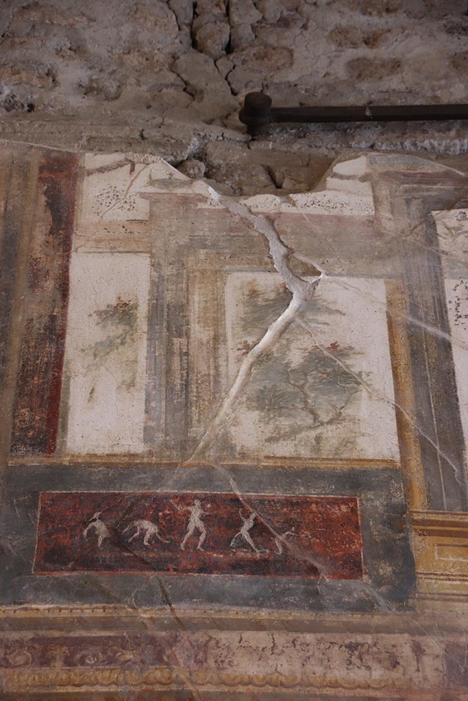 VI.15.1 Pompeii. October 2024. 
Upper south wall, painted decoration with panel below, on east side of central figure.
Photo courtesy of Klaus Heese.
