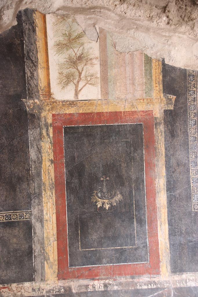 VI.15.1 Pompeii. October 2024. 
Triclinium “t”, detail of painted decoration from west end of south wall. Photo courtesy of Klaus Heese.
