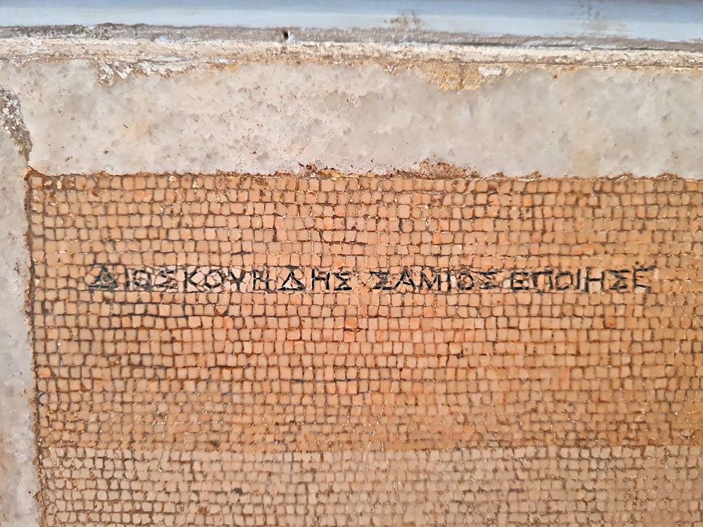 HGW06 Pompeii. Found on 8th April 1763. Ambiente 13 of Villa of Cicero. 
Mosaic of a Group of Street Musicians. Detail of signature of Dioskourides of Samos. 
Now in Naples Archaeological Museum. Inventory number 9985.
Photo courtesy of Giuseppe Ciaramella. September 2024.
