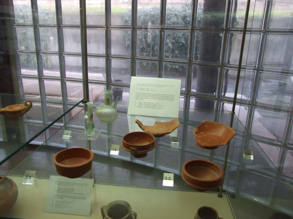 Finds from Villa Regina Boscoreale. December 2006. Now in Boscoreale Antiquarium.
Small glass jug and perfume bottle. Five terra sigillata (red gloss pottery) cups.
