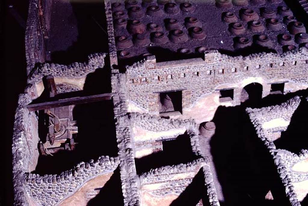 Villa della Pisanella, Boscoreale. 1972. Photograph from model of Villa, room T, the olive press room can be seen in the centre-left.
Room S, the corridor that contained the vessels for the oil can be seen in the centre-right, with arched doorway leading to room Q, cella vinaria.
Photo by Stanley A. Jashemski. 
Source: The Wilhelmina and Stanley A. Jashemski archive in the University of Maryland Library, Special Collections (See collection page) and made available under the Creative Commons Attribution-Non-Commercial License v.4. See Licence and use details.
J72f0514
